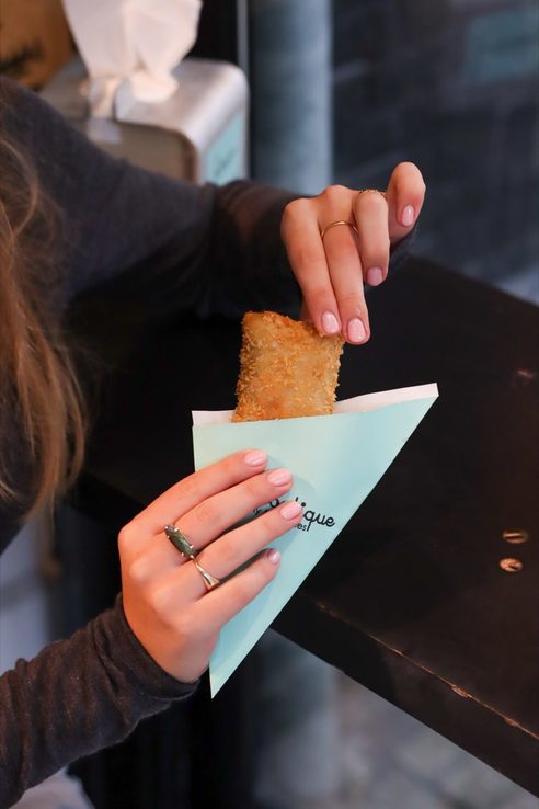Een kroket uit de puntzak, in de hand